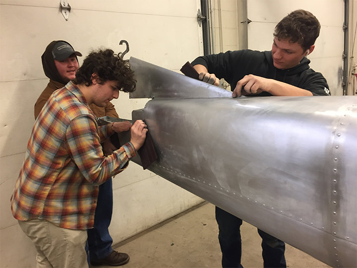 Juniors Tristan Zinc, Jacob Bonagura and Dale McConnell prep the tail section of a Cesssna 150 for a repair.